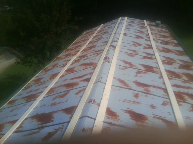 Rusted metal roof panels with new wood purlins before replacement — Storm Damage Roof Repair in Whitewater by Roofing Brothers