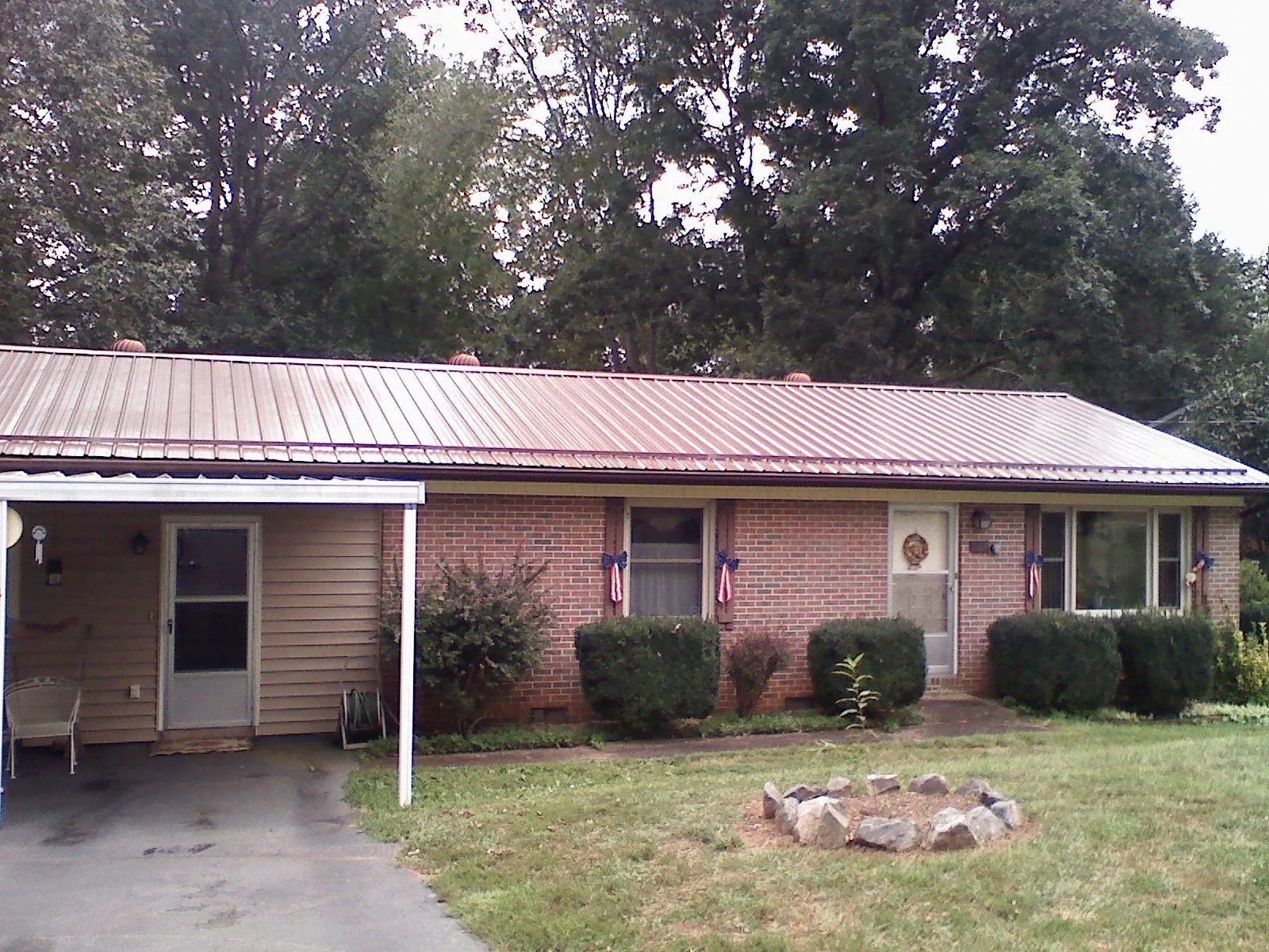 Bronze metal roof and carport on a brick ranch home — Roof Repair work by our crew in Whitewater